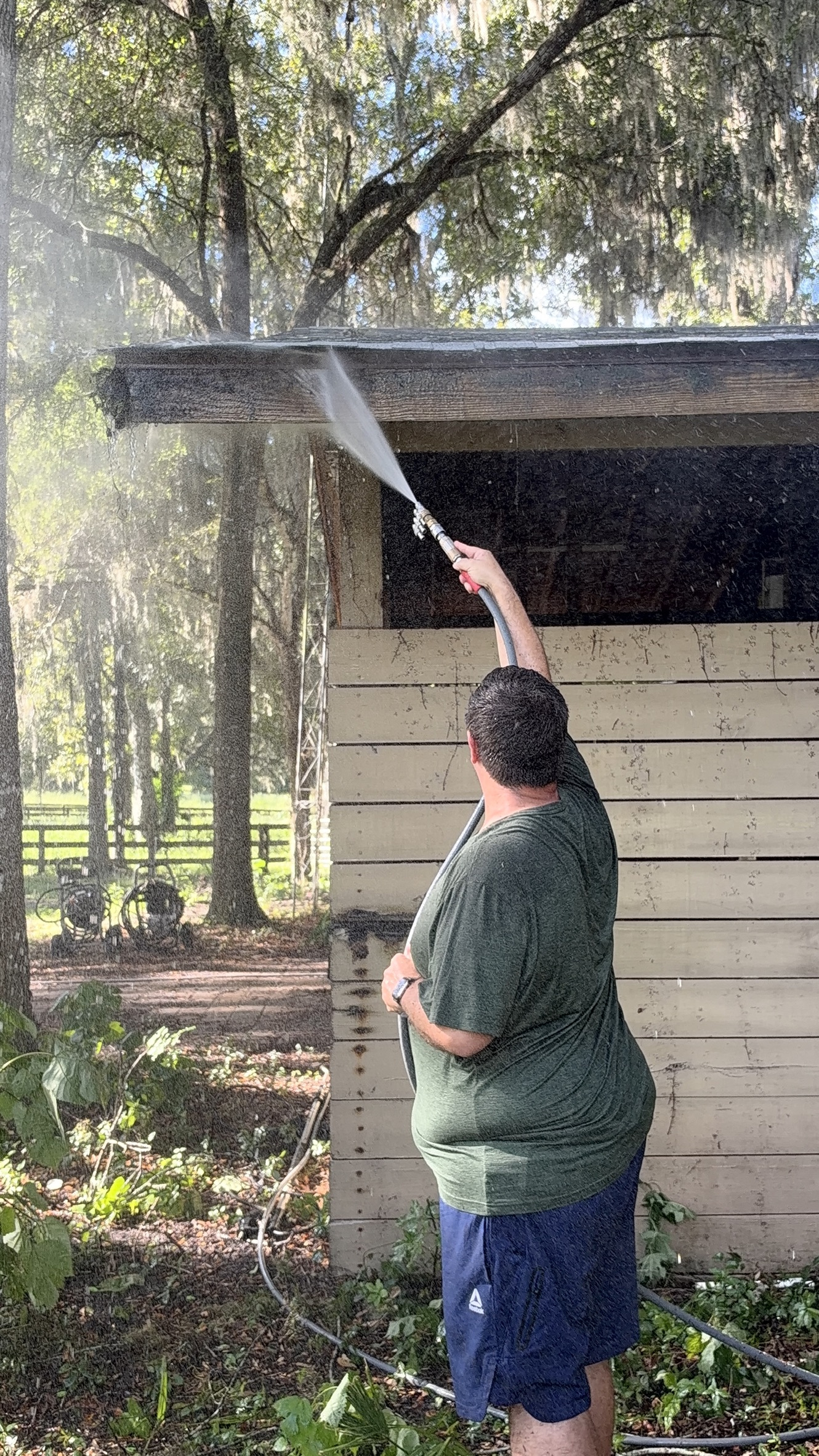 Under Pressure technician washing the eave of a horse barn